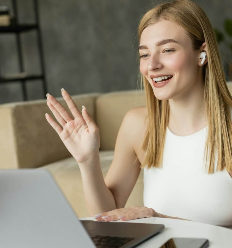 smiling-blonde-coach-in-earphone-having-video-call-on-laptop-at-home.jpg